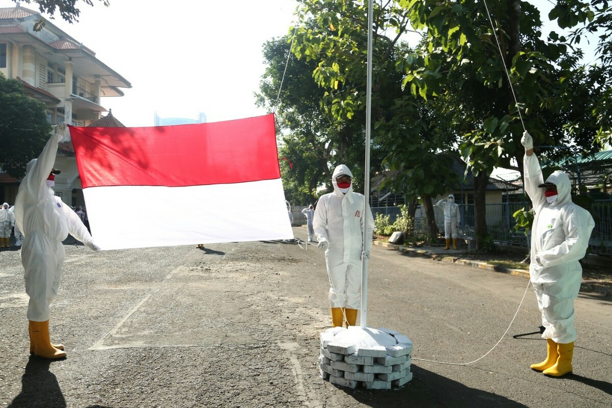 Pakai APD Lengkap, Relawan Surabaya Memanggil Upacara HUT Kemerdekaan di Tempat Isolasi