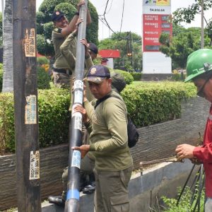 Satpol PP Surabaya Tertibkan 18 Tiang Kabel FO Liar di Jalan Panjang Jiwo
