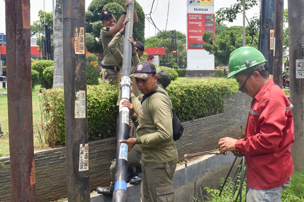 Satpol PP Surabaya Tertibkan 18 Tiang Kabel FO Liar di Jalan Panjang Jiwo